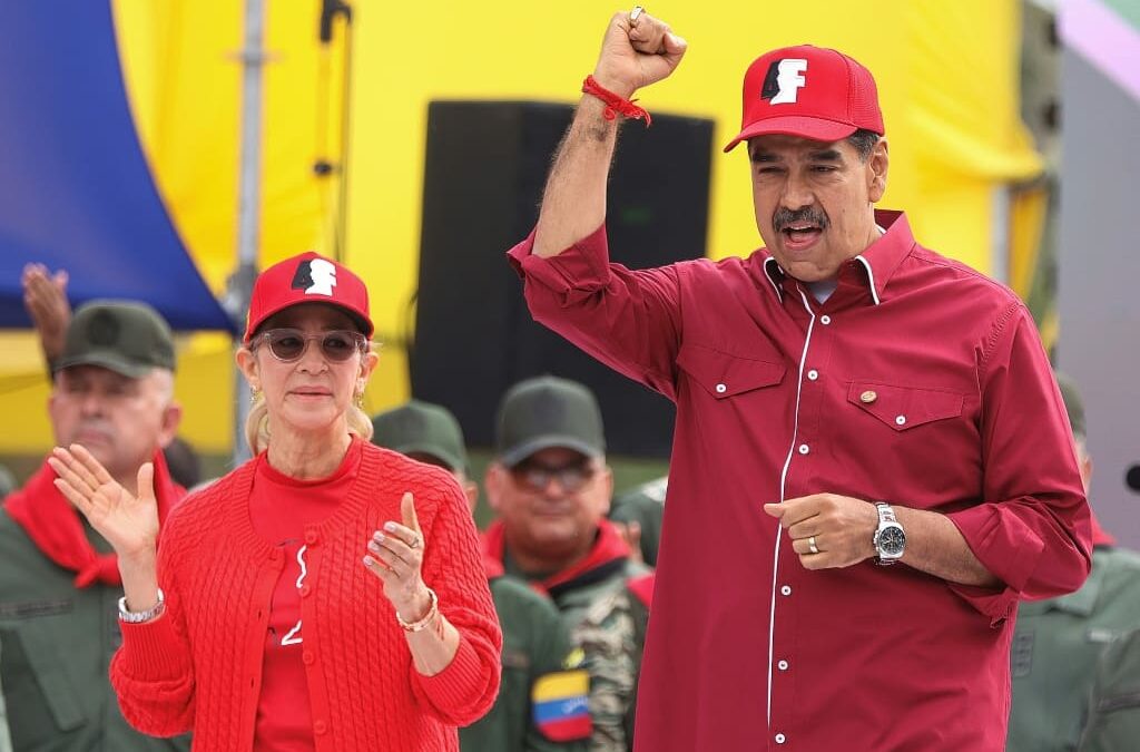 icolás Maduro y Cilia Flores saludan desde una tarima durante un acto oficial