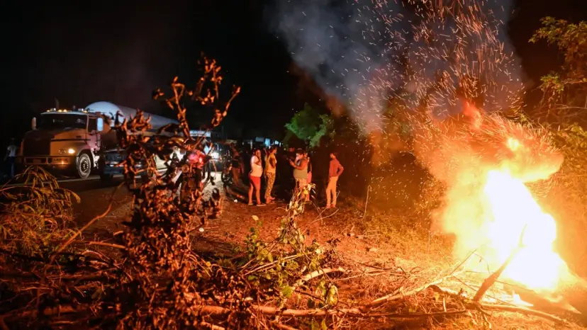 Manifestantes protestan de noche por los racionamientos de electricidad en una calle de Venezuela