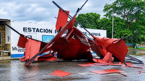 Láminas rojas y vigas del techo de la Estación Policial El Café-Capaya esparcidas sobre la vía mojada tras los vientos en Barlovento, Miranda