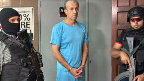 Tareck El Aissami, esposado y custodiado por dos funcionarios armados