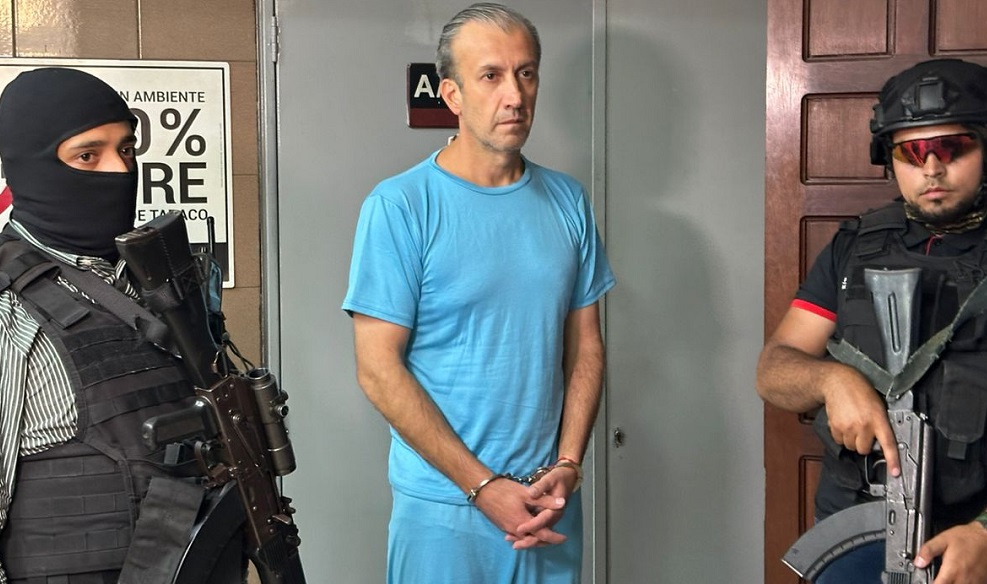Tareck El Aissami, esposado y custodiado por dos funcionarios armados